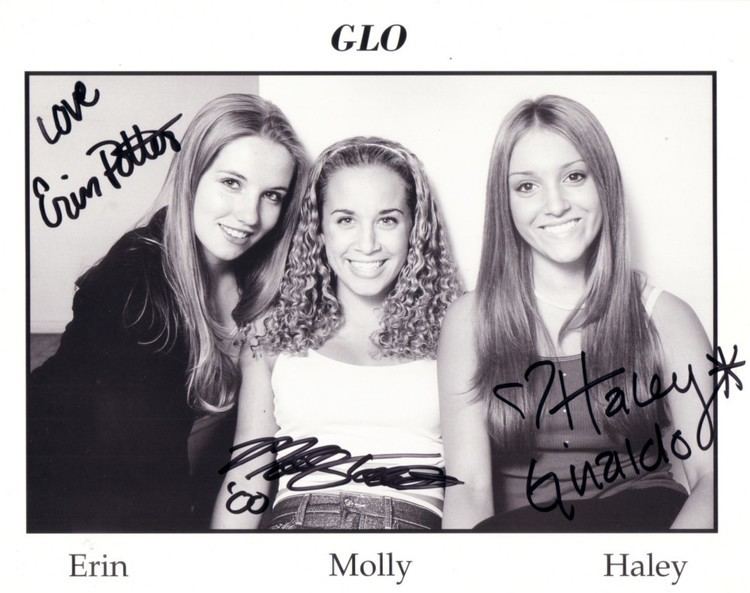 Haley Giraldo smiling with the other members of the band "Glo", Erin and Molly and wearing a black top together with the other members of the band "Glo", Erin and Molly