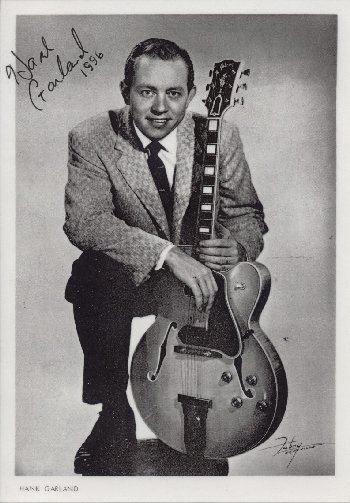 Hank Garland posing while holding a guitar for the Rock Walk Induction.