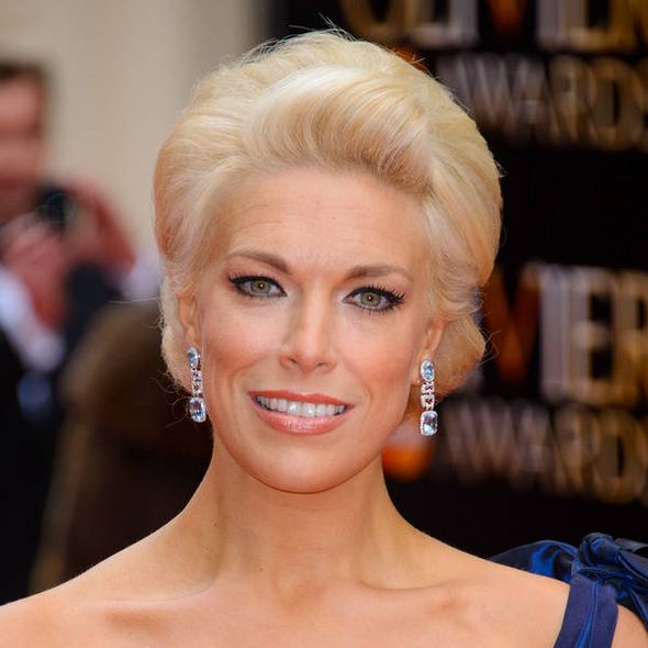 Hannah Waddingham smiling while wearing a blue sleeveless gown and earrings