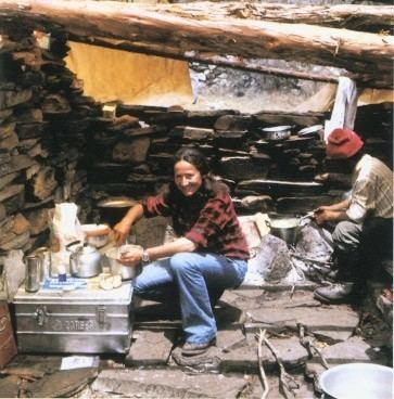 Hannelore Schmatz wearing a red checkered shirt and Gerhard Schmatz  wearing a red hat while cooking at Mount Everest.