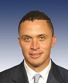 Harold Ford, Jr. smiling and wearing a suit and a tie.