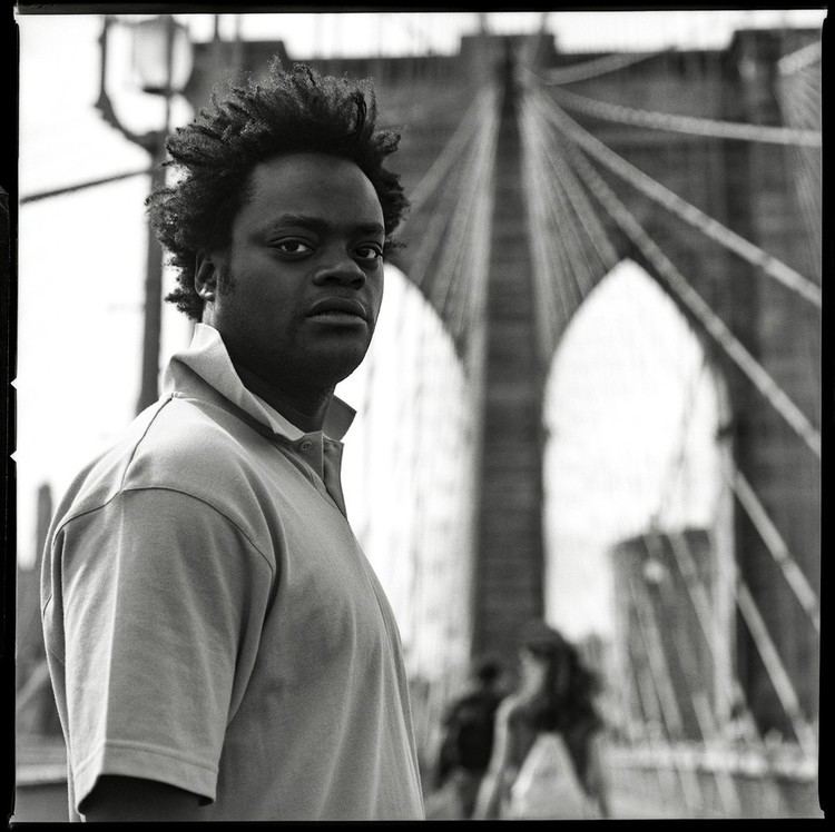 Harold Hunter posing at the bridge while wearing a polo shirt