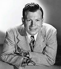 Harold Russell smiles while wearing a formal suit in  black and white