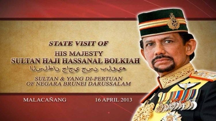 Poster of the state visit of Hassanal Bolkiah with a serious face while looking at something, with a beard and mustache, wearing a multi-colored forage cap with a badge on it, and a multi-colored service uniform with special skills and identification badges.