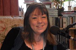 Heather Couper wearing a black blouse, blue vest and necklace