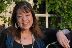 Heather Couper wearing a black blouse, blue vest and necklace