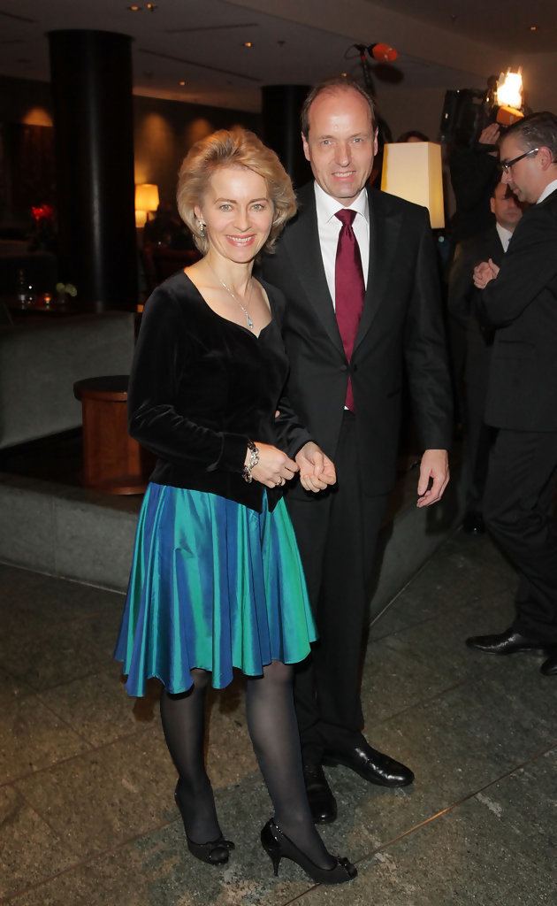 Heiko von der Leyen smiling while wearing a formal suit while Ursula von der Leyen wearing a black long sleeves and a blue skirt