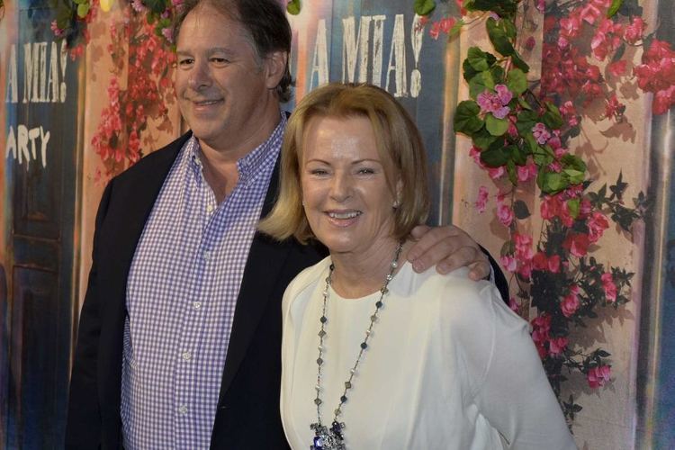 Henry Smith wearing black coat, white and blue long sleeves while Sara Suzanne Anlauf in her white outfit paired with necklace