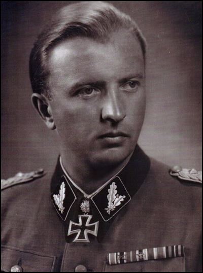 Hermann Fegelein looking afar while wearing gray and black long sleeves with badge