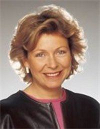 Hilary Kay smiling while wearing a black blazer and violet blouse