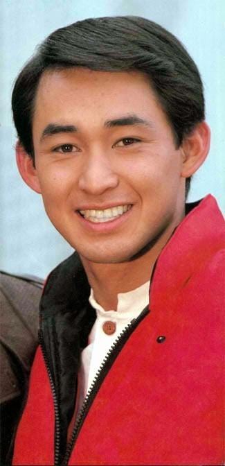 Hiroshi Tsuburaya smiling while wearing a white polo and a black and red jacket