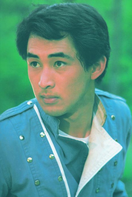 Hiroshi Tsuburaya looking afar while wearing blue long sleeves with gold buttons