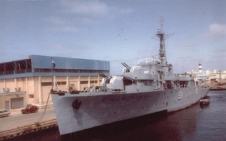 HMS Whimbrel (U29) docked at a port in a dusk hour with cars visible.