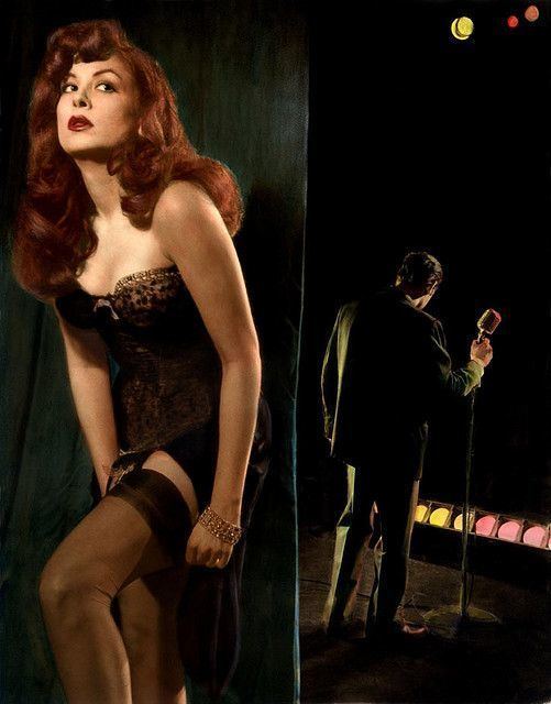 On the left, Billie Madley as "Hot Honey Harlow" (Honey Bruce) in production about Lenny Bruce. Billie with a seductive face, wavy hair, wearing black see-through lingerie and black tights.On the right, a man holding a microphone stand in front of stage lights, wearing a black coat and black pants.