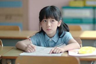 Re Lee answering the test paper while wearing a blue polo blouse in a movie scene from the 2013 film Hope