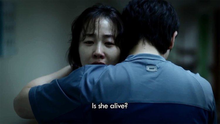 A man hugging Ji-won Uhm while she is crying in a movie scene from the 2013 film Hope