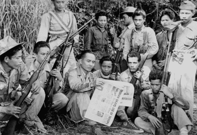 Few members of Hukbalahap, the Hukbong Bayan Laban sa Hapon, wearing their uniforms and some members are holding riffles.