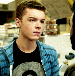 Ian Gallagher wearing a blue striped jacket and black printed t-shirt