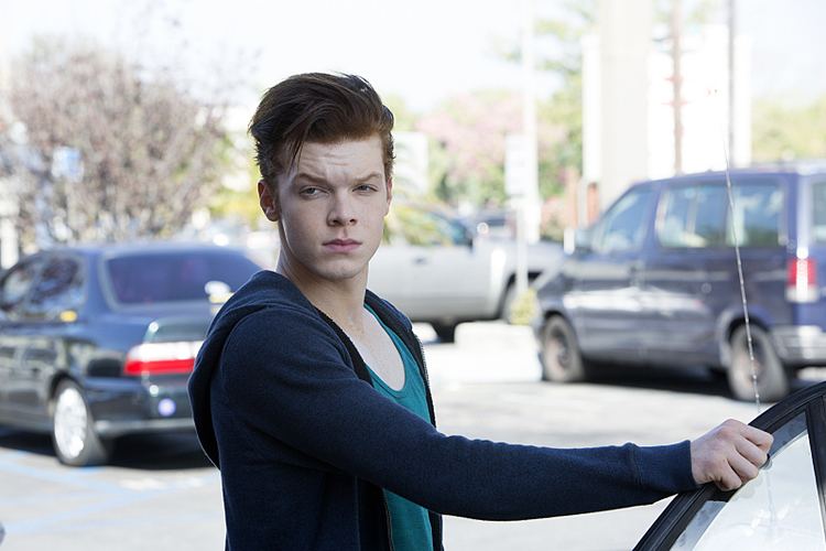 Ian Gallagher's serious face while wearing a blue jacket and green sando