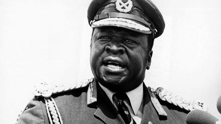Idi Amin talking to someone while wearing a military uniform