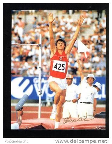 Igor Paklin competing in the high jump while wearing a red jersey with the number 425 and white shorts