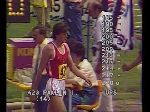 Igor Paklin competing in the high jump while wearing a white and red jersey