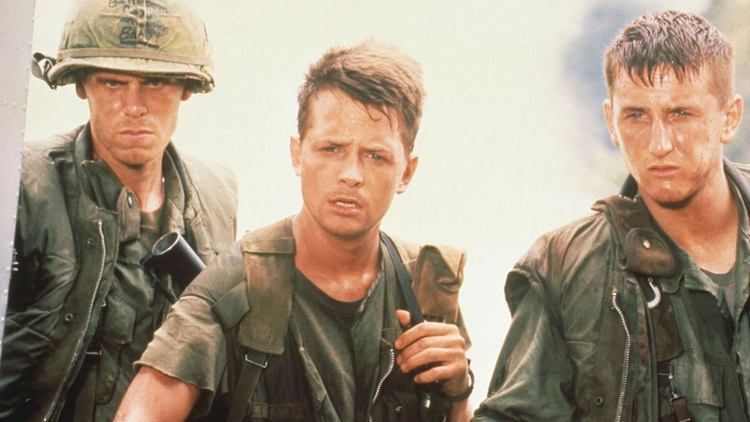 Michael J. Fox, Sean Penn, and Don Harvey wearing a soldier's uniform in a scene from the 1989 film, Casualties of War