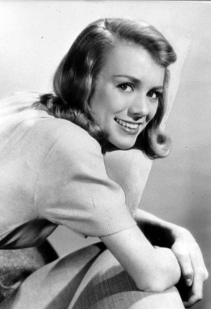 Inger Stevens smiling with short curly hair while wearing a blouse