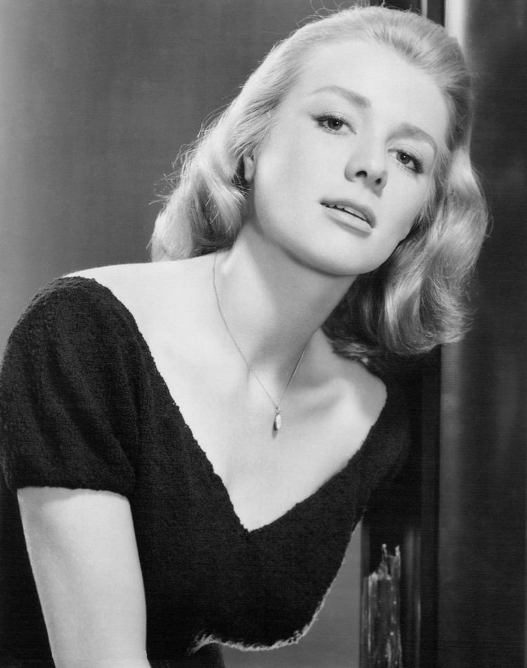 Inger Stevens posing with shoulder-length curly hair while wearing a blouse and necklace