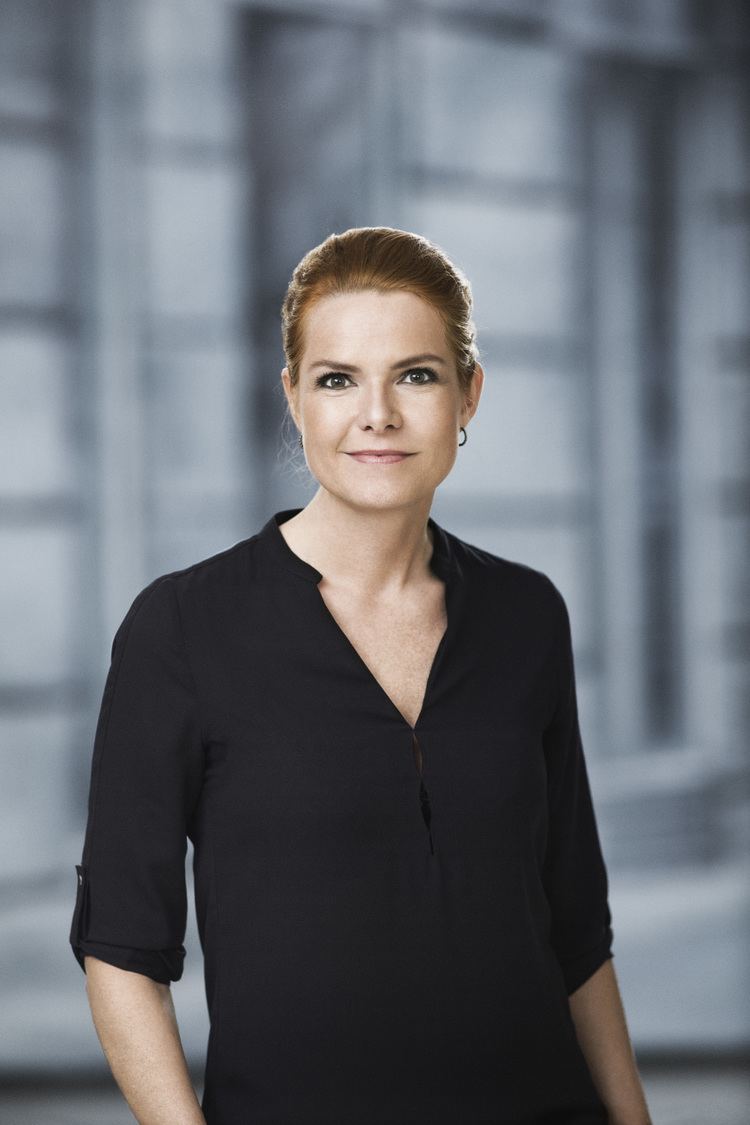 Inger Støjberg smiling with her hands in her pocket and wearing a black dress.