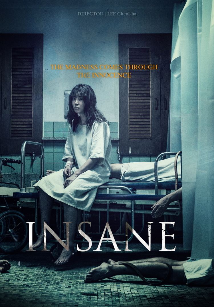 The poster of the Insane (2017), in a closed room with wooden window and white wall with blue tiles, with a bed with a dead body at the back and in front of her at the ground wearing white hospital robes, Kang Ye-won is serious, sitting in hospital bed has long black hair wearing a white hospital robes with a bandage on her right hand,at the top is “DIRECTOR I LEE Cheol-ha” in the middle “THE MADNESS COMES THROUGH THE INNOCENCE” at the bottom is the title “INSANE”