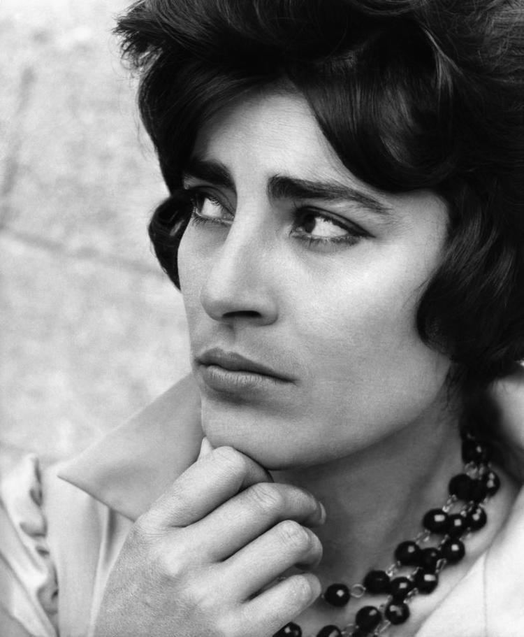 Irene Papas looking serious while looking at the side while wearing a blouse and  necklace