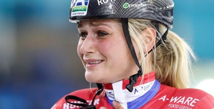 Irene Schouten looking tearful with blonde hair and wearing a red jacket and black helmet with prints
