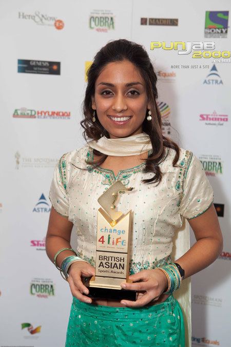 Isa Guha in her cream and green beaded dress as she receives her award