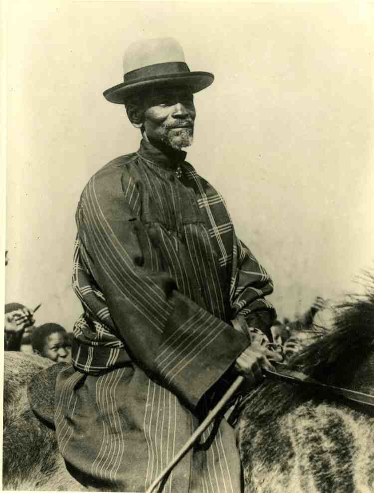 Isaiah Shembe riding in a horse while wearing hat and striped dress