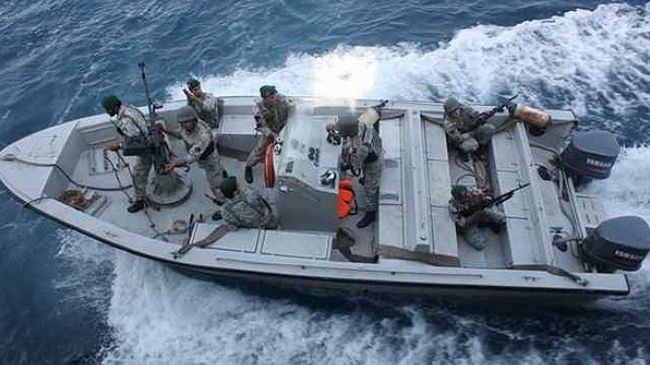 Eight Iranian Navy wearing their uniforms with rifles riding a boat.