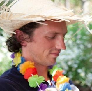 Israel Keyes wearing a flower necklace and a hat