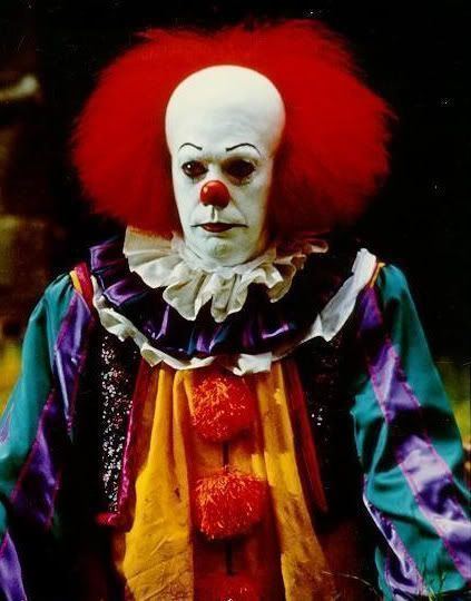 Tim Curry as Pennywise, with a sad face while wearing colorful long sleeves, in a scene from the 1990 horror drama miniseries, It