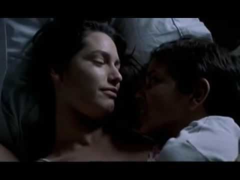 Fernanda Serrano smiling and looking at Saúl Fonseca while lying on the bed in a scene from the 1999 Portuguese drama film, Jaime