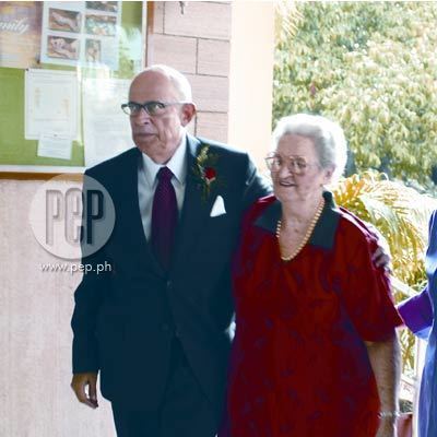 Jaime Fabregas wearing black coat, white long sleeves and neck tie and the woman besides him wearing red dress