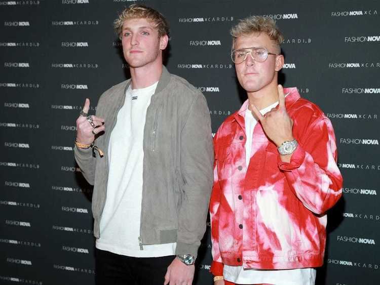 Logan Paul and Jake Paul posing with a sign of the horns hand gesture at the Fashion Nova Presents: Party With Cardi at Hollywood Palladium