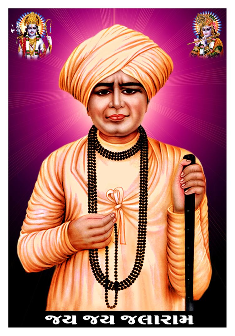 Jalaram Jay holding a wooden stick and a black necklace while wearing an orange turban, orange long sleeves, and a black beaded necklace