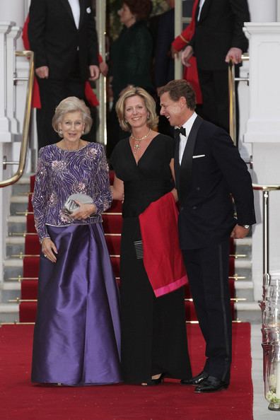 James Ogilvy smiling with Princess Alexandra and Julia Ogilvy while he is wearing a black coat, white long sleeves, black pants, and bow tie