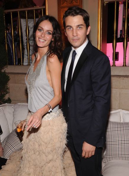 Nicole Trunfio smiling and wearing a gray and beige gown while Jamie Johnson wearing a black coat, white long sleeves, and a black necktie