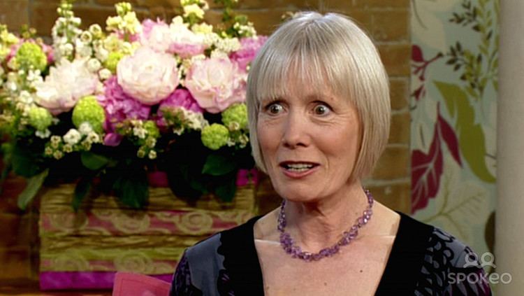Jane Wymark in one of her interviews while wearing a black and blue dress and a violet necklace