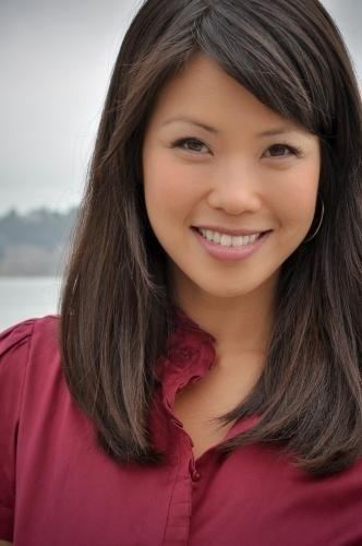 Janelle Wang smiles while wearing a red sleeve outdoor