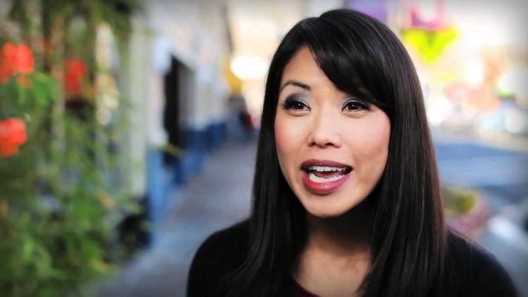 Janelle Wang talking while wearing a black sleeve outdoor