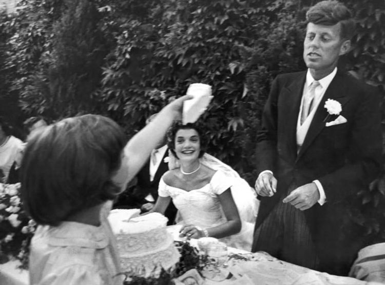 The wedding of John F. Kennedy and Jacqueline Bouvier in Newport, Rhode Island on September 12, 1953, and Janet Jennings Auchincloss as their flower girl offers Kennedy a piece of cake.