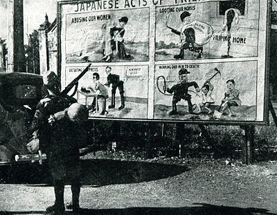 An Imperial soldier staring at an Anti-Japanese propaganda billboard