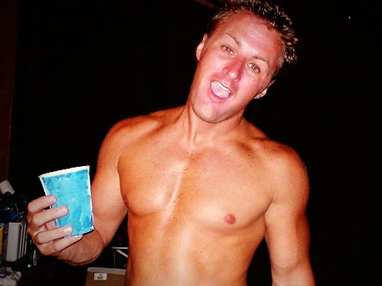 Jason Derek Brown holding a cup while in topless